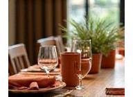 Eettafel aangekleed met terracotta keramiek en natuurlijke accessoires